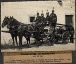 Bombeiros e uma bomba de água num carro puxado por uma parelha de cavalos